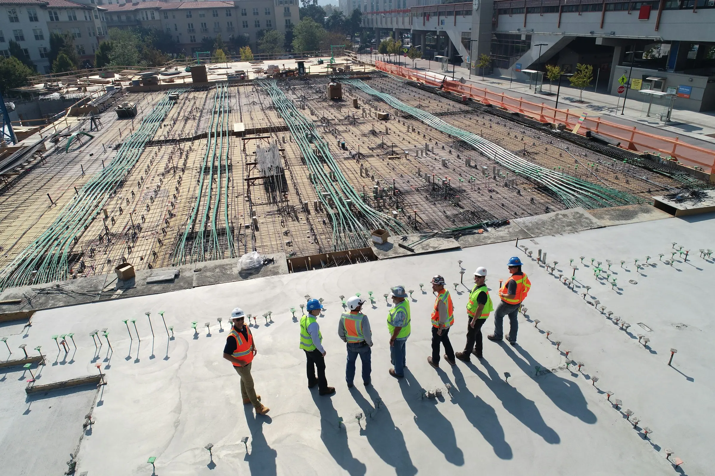 Luftaufnahme einer Baustelle mit Bauarbeitern in Warnwesten